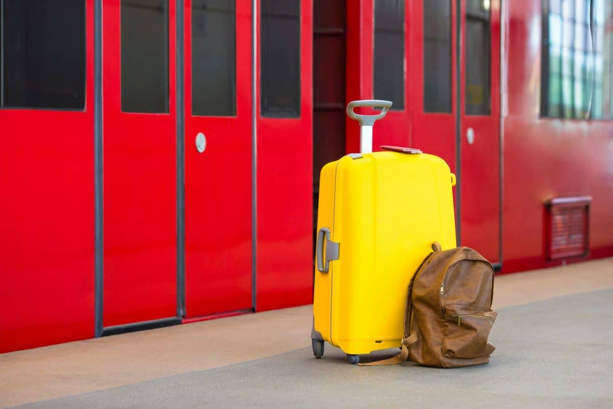 Bagages jaunes avec passeports et sac à dos marron à la gare