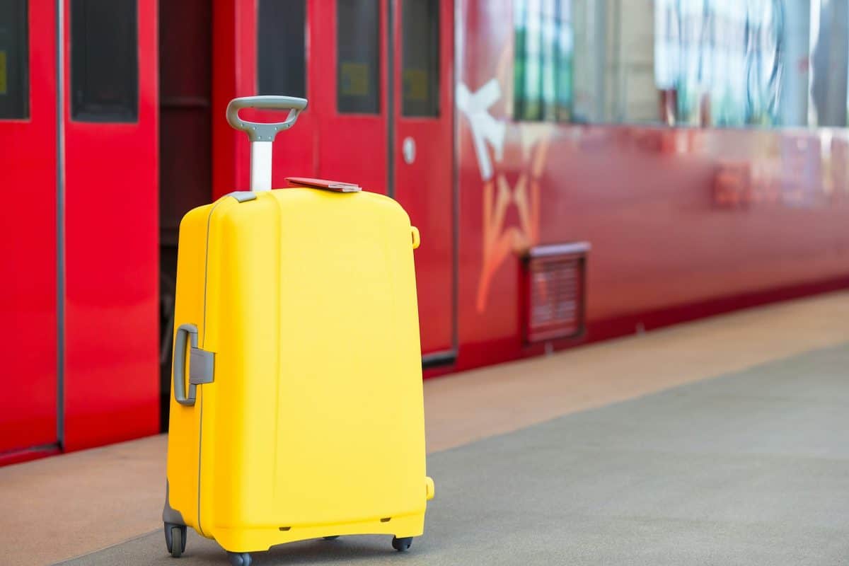 Deux passeports sur un bagage jaune à la gare