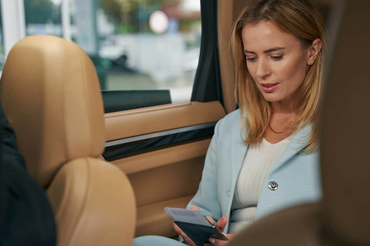 Woman with a boarding pass sitting in a car