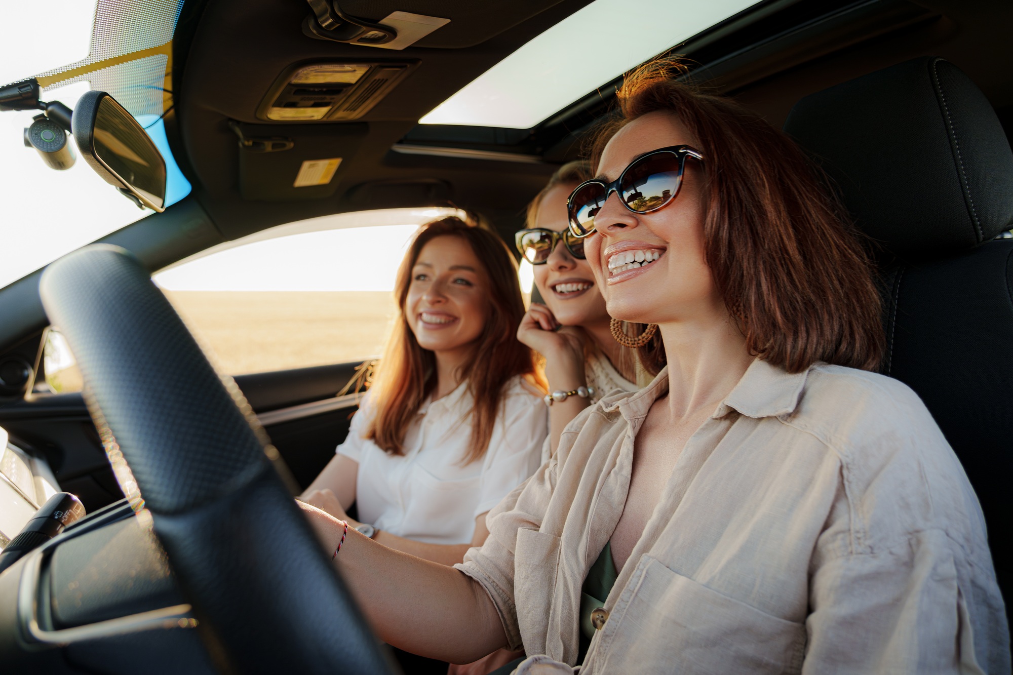 Femmes joyeuses assises dans une voiture en vacances