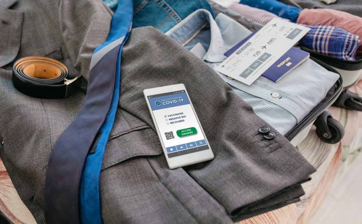 Hombre de negocios preparando su maleta para un viaje de negocios con un pasaporte covide