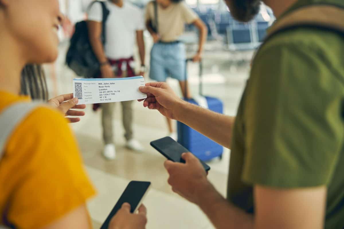 Man asking a woman for her boarding pass at the airport