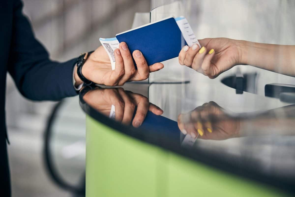 Voyageur montrant son passeport et ses billets d'avion à la réceptionniste